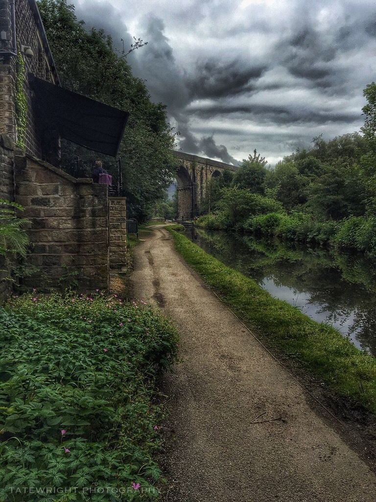 FOOTPATH LEADING TO HOUSE AGAINST CLOUDY SKY