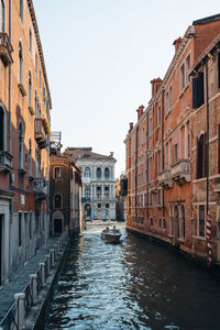 Boat on a narrow canal in venice, italy.