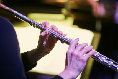 Cropped hands of musician playing flute