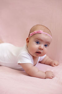 Portrait of cute baby boy lying on bed at home