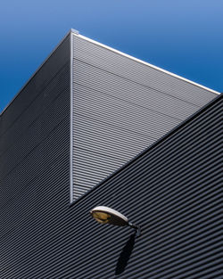 Low angle view of modern building against clear blue sky