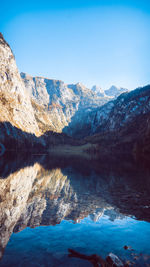 Scenic view of lake and mountains against blue sky