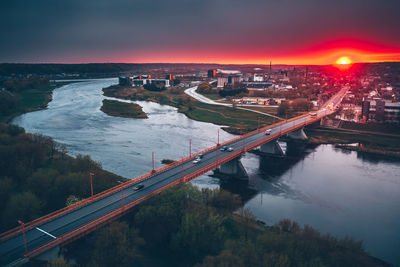 Aerial view of bridge over river in city against sky