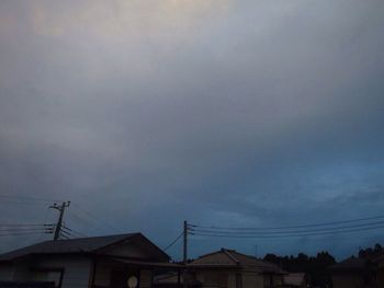 Low angle view of silhouette electricity pylon against sky