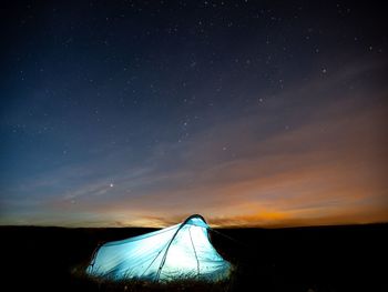 Scenic view of silhouette field against sky at night