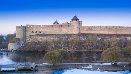 View of building by river against clear sky