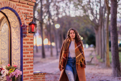 Portrait of young woman standing in park