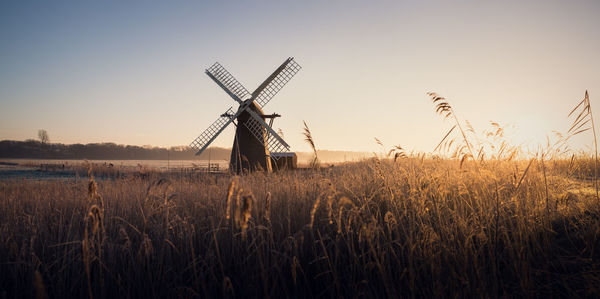 Traditional windmill on field against sky