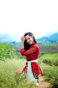 Portrait of an indonesian woman, wearing a red balinese kebaya.