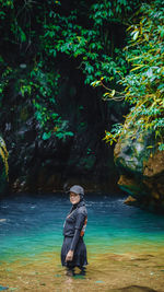 Portrait of woman standing in river at forest