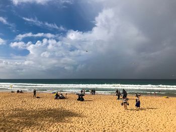 People on beach against sky