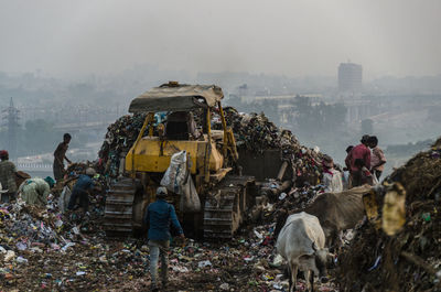 People standing by houses in city against sky