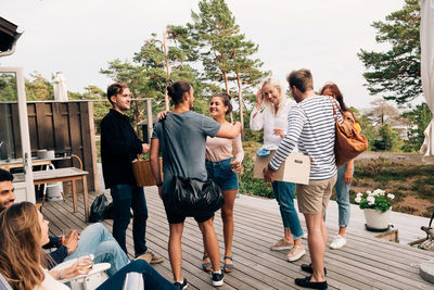 Happy friends greeting each other on cottage deck