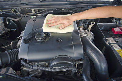 Hand cleaning car engine with a rag,worker
