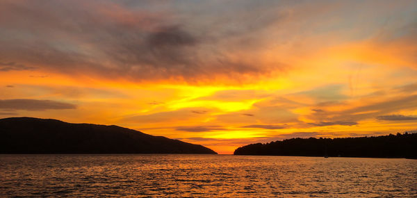 Scenic view of sea against dramatic sky during sunset