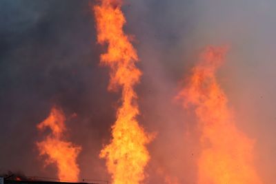 Low angle view of fire against sky during sunset