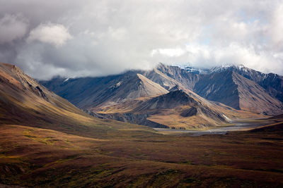 Scenic view of mountain range against cloudy sky