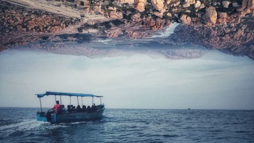 Digital composite image of boat in sea below landscape