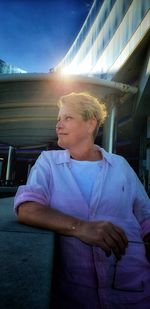 Woman looking away against blue sky