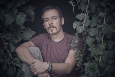 Portrait of mid adult man standing by plants