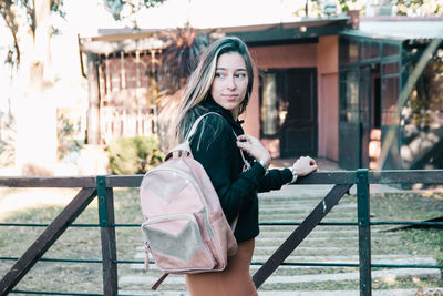 Beautiful woman wearing backpack returning home