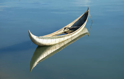 Close-up of boat moored in lake against sky