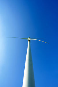 Low angle view of windmill against clear blue sky