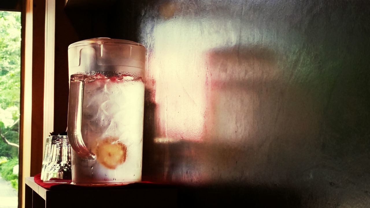 indoors, table, glass - material, freshness, drink, still life, food and drink, transparent, vase, window, refreshment, wood - material, flower, glass, home interior, close-up, drinking glass, window sill, jar, potted plant