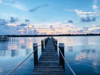 Pier over lake against sky during sunset