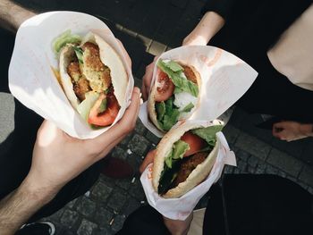 Three people holding burgers