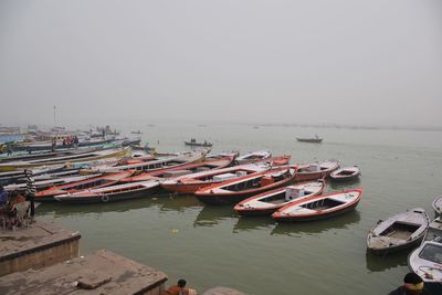 Boats moored in sea against clear sky