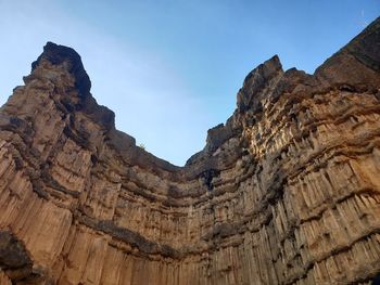 Low angle view of rock formation against sky