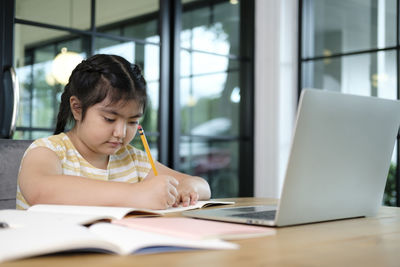 Girl sitting on table at home