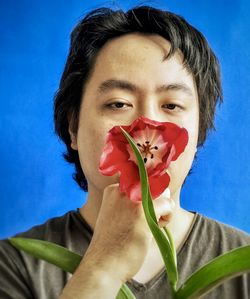 Close-up portrait of woman holding red flower