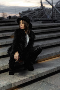 Portrait of young woman sitting on staircase