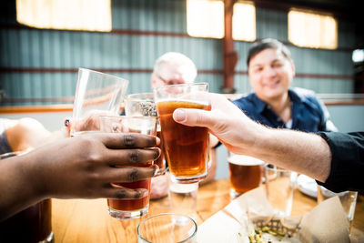 Close-up of people toasting with beer