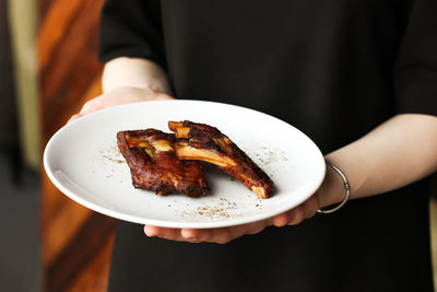 Spicy smoked beef baked pork chops ribs with spices and pepper snack to beer in white plate 