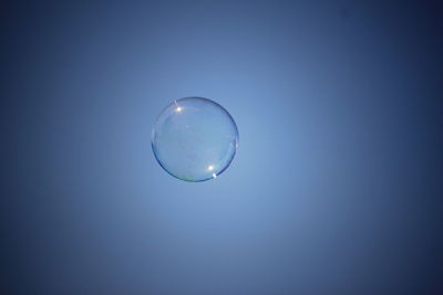 Close-up of bubbles against clear blue sky