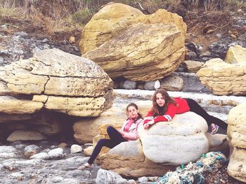 Portrait of woman sitting on rock