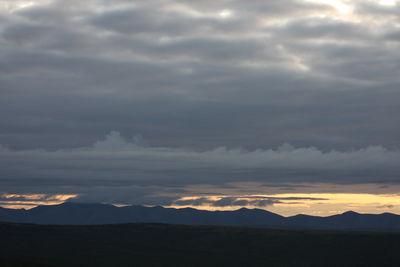 Scenic view of silhouette mountains against sky during sunset