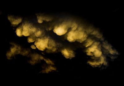 Low angle view of sun shining through clouds