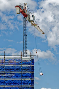 Low angle view of crane against sky