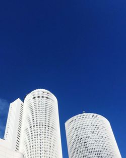 Low angle view of modern buildings against blue sky