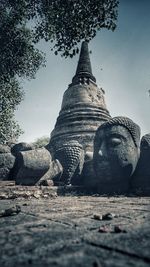 Low angle view of buddha statue against sky