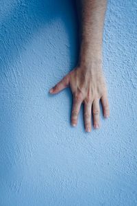 Close-up of hand touching wall