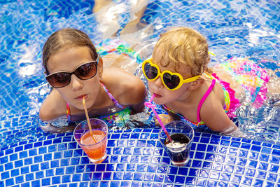 Portrait of woman wearing sunglasses in swimming pool