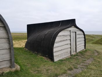 Built structure on field against sky