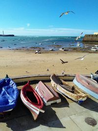 Boats moored on beach against sky