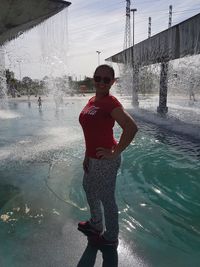 Full length portrait of young man standing in water