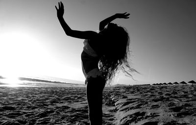 Woman standing on beach against clear sky